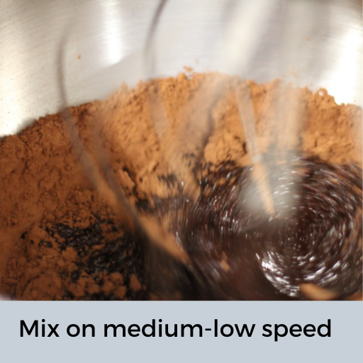 butter, sugar and cocoa being mixed in a mixer